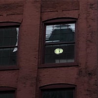 a red brick building with a clock in the window