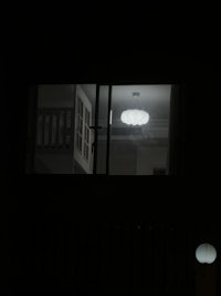 a window in a dark room with a light in it