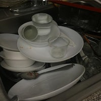 a sink full of dishes and utensils