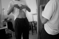 a man standing in front of a mirror