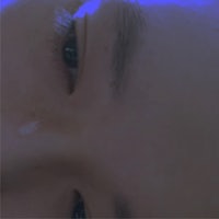 a close up of a woman's face with a blue light