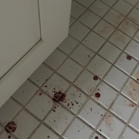 blood splatters on the floor of a bathroom