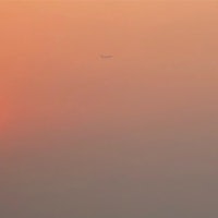 a plane flying over a smoggy sky